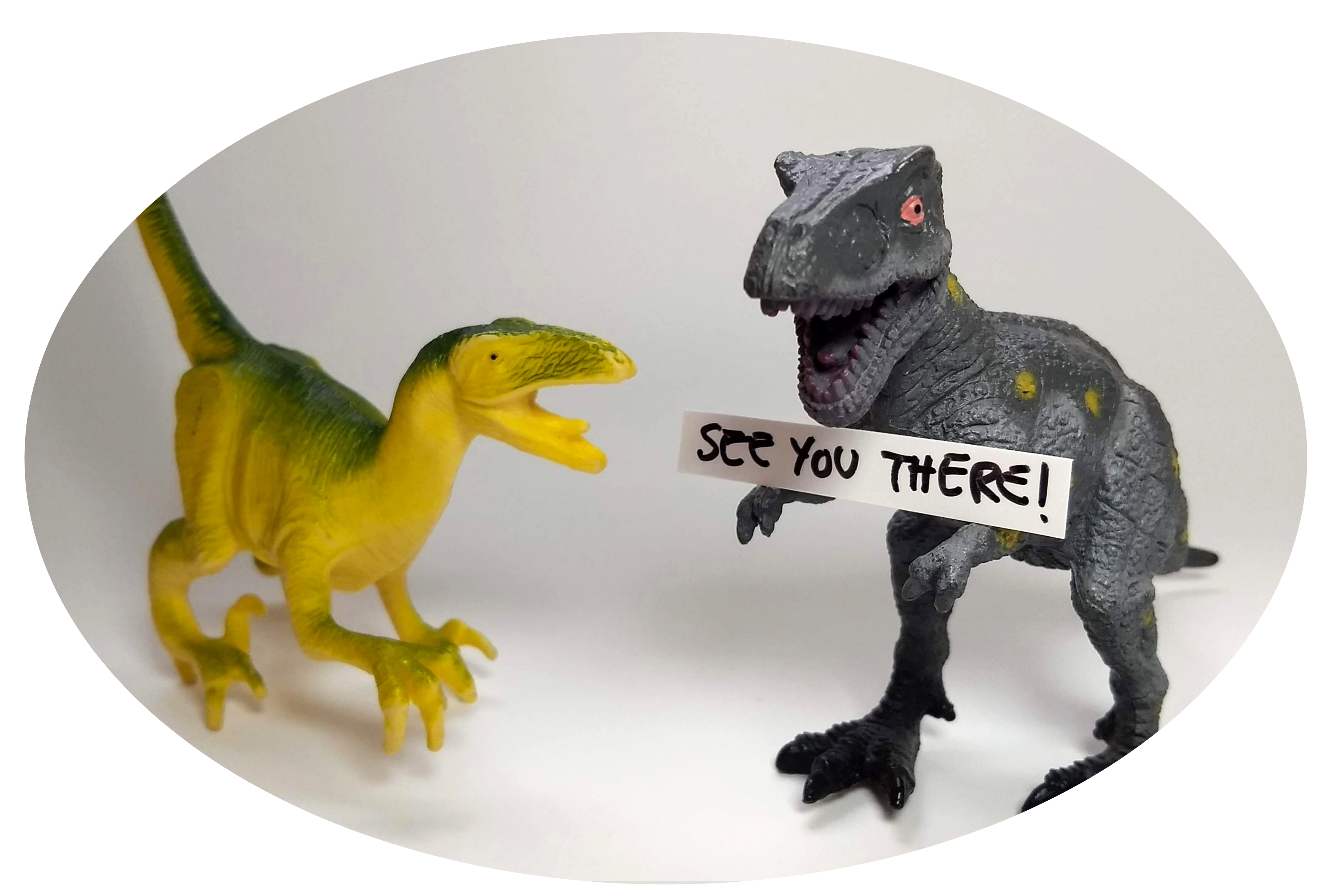 Two toy dinosaurs. One is holding a sign: "See you there!"